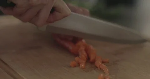 Chopping carrots on a cutting board Stock Footage 76405725