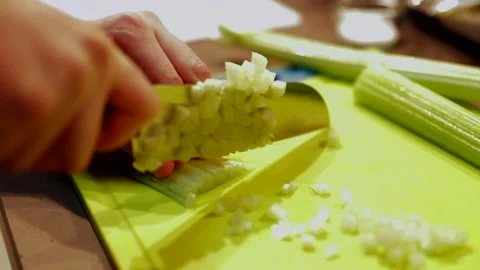 Chopping celery on green cutting board in slow motion Stock Footage 149118639