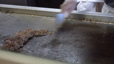 Chopping a cheese steak on a griddle Stock Footage