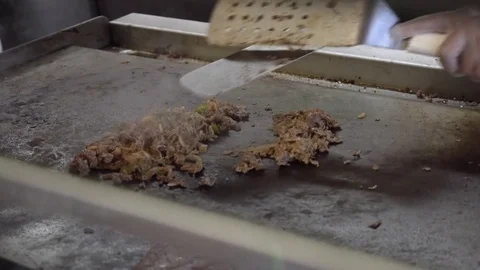 Chopping a cheese steak on a griddle Stock Footage 78094859