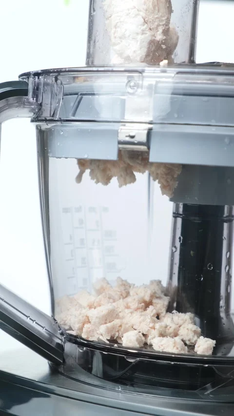 Chopping cooked chicken breast with a kitchen machine for salad prep. Stock Footage 327120189