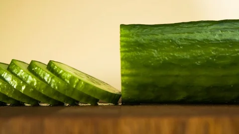 Chopping cucumber. Closeup of sliced vegetable on wooden cutting board. Stop Stock Footage 129519200