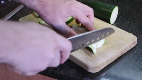 Chopping cucumber for fresh salad preparation in a home kitchen Stock Footage 294623341