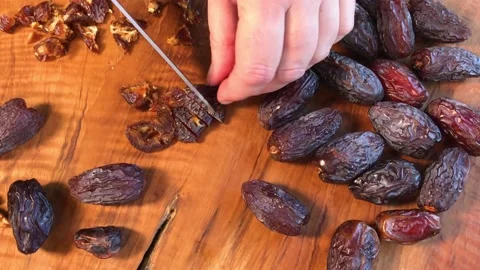 Chopping dried Medjool dates on cutting board flat lay Stock Footage 144004947
