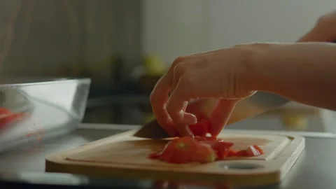 Chopping fresh tomatoes in the kitchen for a delicious meal preparation Stock Footage 323367104