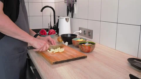 Chopping fresh vegetables in a sleek kitchen setup. Colorful bowls filled with Video stock 316475689