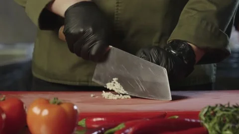 Chopping garlic close-up. Chef prepares garlic for marinade. Stock-Footage 231430941
