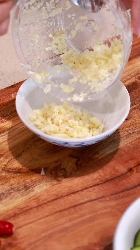 Chopping Garlic with Manual Chopper in Kitchen Stock Footage 307370633