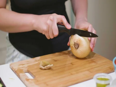 Chopping an onion on a cutting board Stock Footage