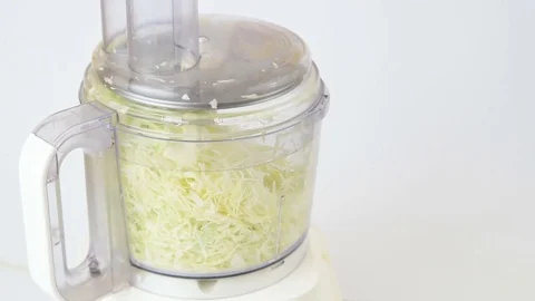 Chopping onions in a food processor on white Stock Footage 82614881