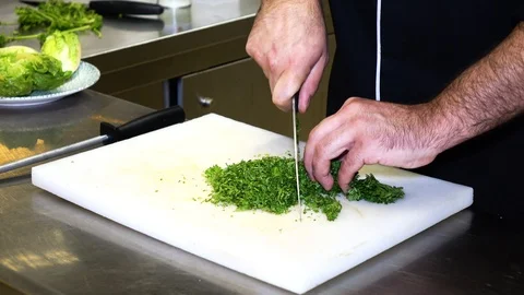 Chopping parsley at a restaurant kitchen 動画素材 98457709