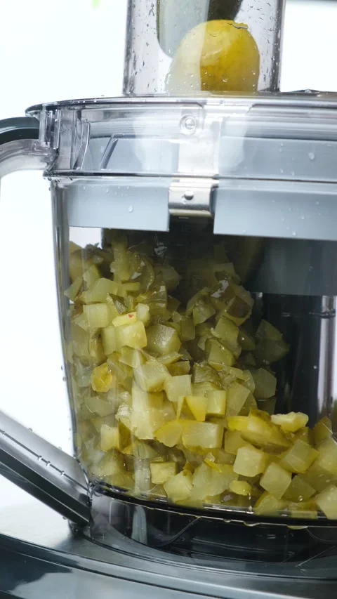 Chopping pickles with a kitchen machine for salad preparation. Food processor Stock Footage 327120128