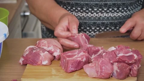 Chopping pork into even cubes on cutting board. Unrecognizable person slicing Video stock 319159665
