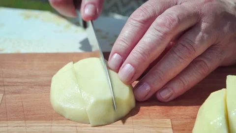 Chopping potato pieces precisely, steady hands slicing potato halves Stock Footage 326022775