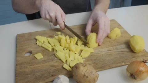 Chopping Potatoes in a Modern Kitchen for Delicious and Nutritious Meals and Stock Footage 305280705