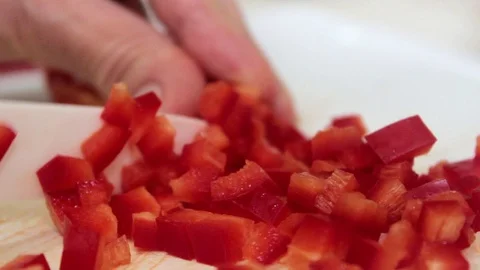 Chopping Red Bell Pepper Into Small Cubes on Cutting Board 125816579
