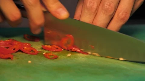 Chopping red peppers on a green background Stock Footage