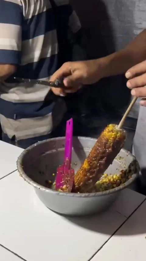 Chopping roasted corn on a wooden cutting board with some fruit, make jasuke Stock Footage 309980533