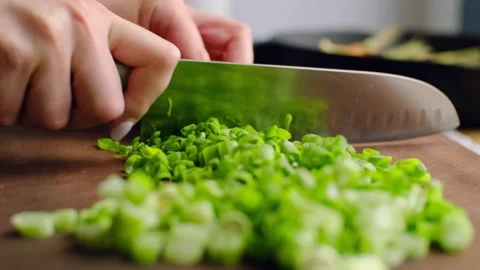 Chopping spring onion. Chef cutting raw green onion with knife, chopped organic Stock Footage 245258045