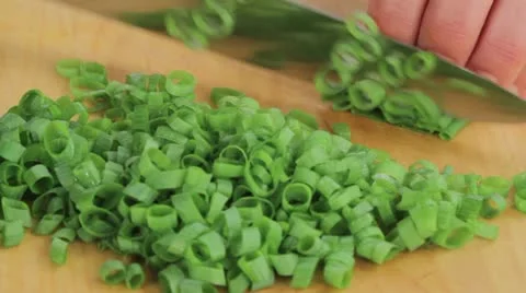 Chopping spring onion leaves into fine rings Video stock 24666716
