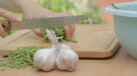 Chopping string green beans into equal parts on wooden board Stock Footage 8367429