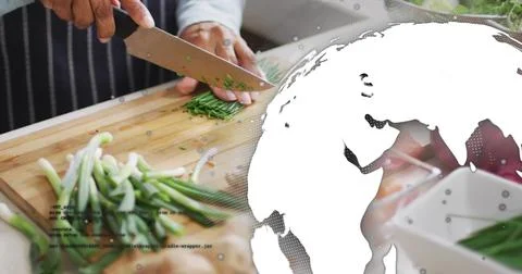 Chopping striped-apron cook using chef knife in kitchen on board with chopped Stock-Fotos