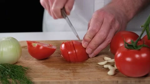 Chopping tomatoes on table Stock Footage 199312579