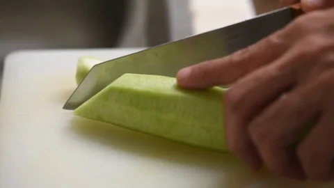 Chopping zucchini on white board Stock Footage 97000579