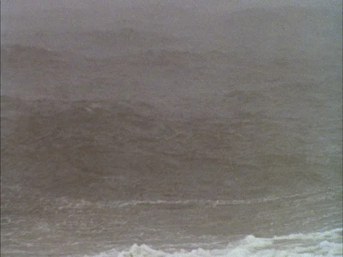 Choppy gray surf with white caps with falling snow Video stock 86750380