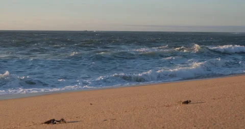 Choppy ocean waves breaking on sandy beach. Slow zoom out. Stock Footage 146674093