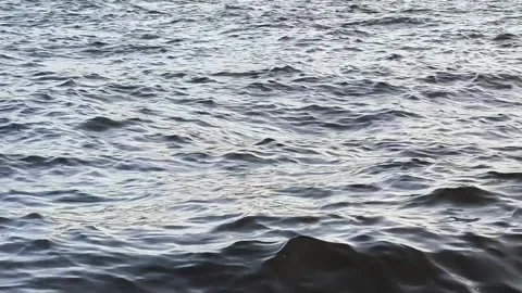 Choppy silver waves on river with reflection under cloudy sky. ?estless and d Stock Footage 328919087