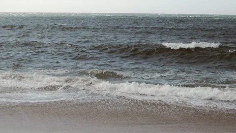 Choppy waves breaking on beach at dusk with desaturated, cold look 库存影片 115787901