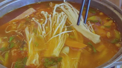 Chopsticks Adding Enoki Mushrooms to Tomato Hot Pot 스톡 동영상 314985000