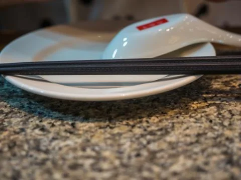 Chopsticks on angular white dish, parallel Foto stock