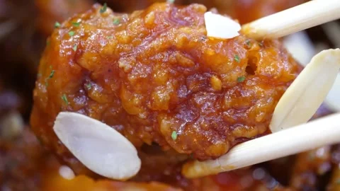 Chopsticks Picking Up Crispy Korean Fried Chicken (Dakgangjeong) Glazed in Stick Video stock 343027840