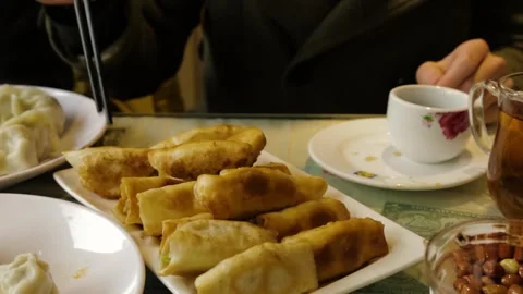 Chopsticks Picking Up Fried Dumplings with Tea at Restaurant Table in Beijing Stock Footage 345745294