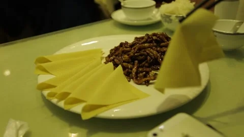 Chopsticks Picking Up Stir-Fried Strips and Wrappers at Beijing Restaurant Table Stock Footage 345745575