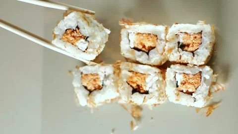Chopsticks taking portion of sushi roll. Sushi rolls with salmon cream cheese Stock Footage 292117142