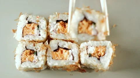Chopsticks taking portion of sushi roll. Sushi rolls with salmon cream cheese Stock Footage 293195565