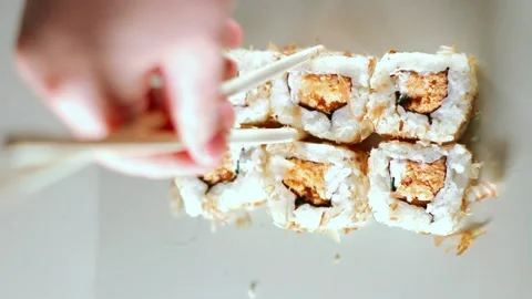 Chopsticks taking portion of sushi roll. Sushi rolls with salmon cream cheese Stock Footage 293195622