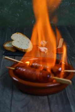 Chorizo grilled chorizo al infierno in a clay pot with bread olives and paprika Stock Photos