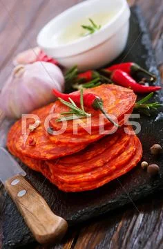 Chorizo on wooden board on a table Stock Photos
