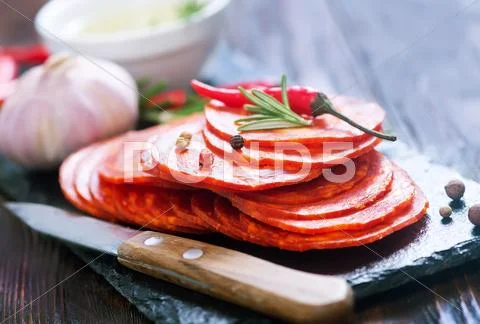 Chorizo on wooden board on a table Stock Photos