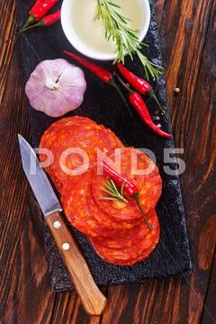 Chorizo on wooden board on a table Stock Photos