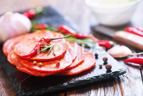 Chorizo on wooden board on a table Stock Photos