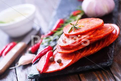 Chorizo on wooden board on a table Stock Photos