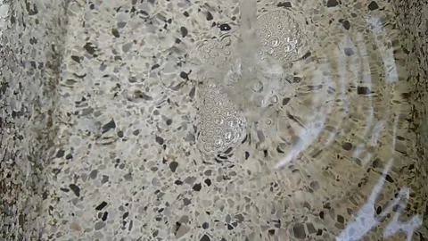 Chorro de agua llenado un tanque de granito, sonido de agua Stock Footage