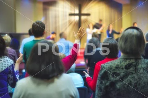 Christian congregation worship God together, with cross with light rays in ba Stock Photos