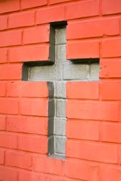 Christian cross between bricks Stock Photos