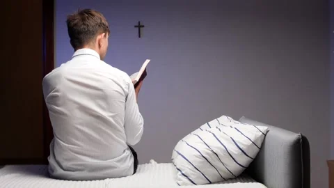 Christian Young man reading scripture in bedroom at night Video stock 317491412